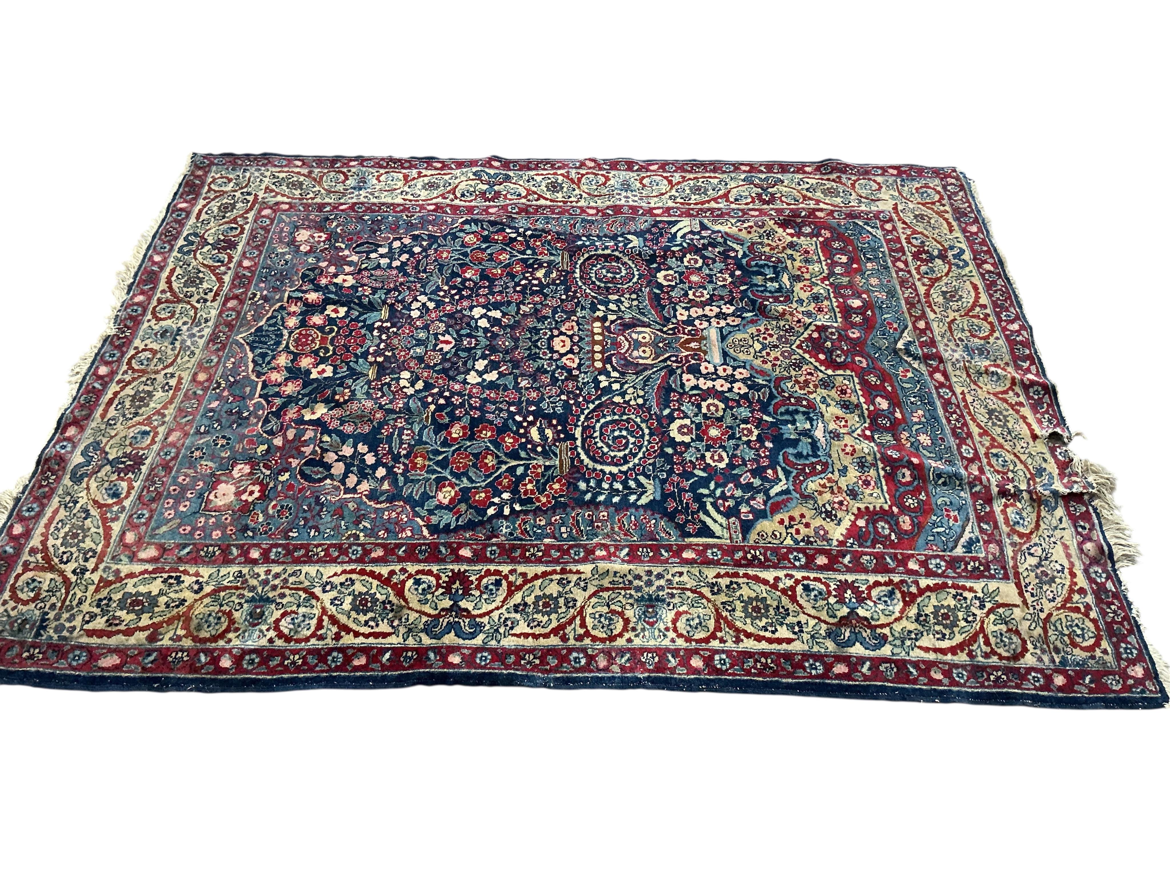 An early 20th century Persian Kashan prayer rug, the central blue ground field with a flower vase within multiple borders, 189 x 145cm